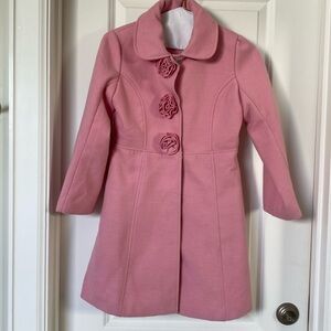 Pink dressy girls coat with rosettes.